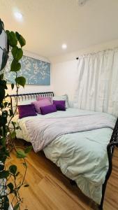 a bedroom with a bed with purple pillows on it at Perfect staycation in Ohio City, walk to W 25 st in Cleveland