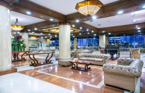 un vestíbulo con sofás, mesas y un piano en Tequendama Bogotá, en Bogotá