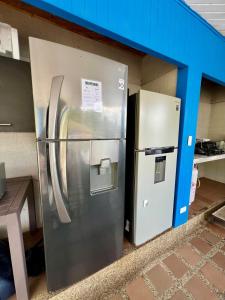 Chalet Lago Calima - Piscina Natural y Jacuzzi في كاليما: ثلاجة وخزانة ملابس موضوعتان في مبنى