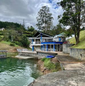 Chalet Lago Calima - Piscina Natural y Jacuzzi في كاليما: البيت الأزرق على جانب النهر