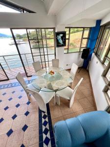 Chalet Lago Calima - Piscina Natural y Jacuzzi في كاليما: غرفة طعام مع طاولة وكراسي زجاجية