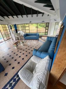 Chalet Lago Calima - Piscina Natural y Jacuzzi في كاليما: غرفة معيشة مع أرائك زرقاء وأريكة