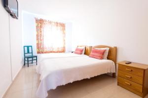 una camera con un letto, una finestra e una sedia di Vila Apartment - Duna Parque Resorts & Hotels a Vila Nova de Milfontes Altre 5 foto