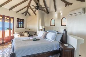 a bedroom with a bed with a ceiling fan at Casa Sonora - Ocean View in Carrillo