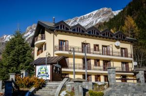 VivimiHome - Rifugio Genzianella في سان دومينيكو: مبنى اصفر كبير مع جبل في الخلفية