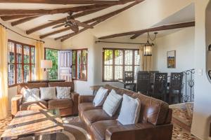 a living room with leather couches and a table at Casa Sonora - Ocean View in Carrillo
