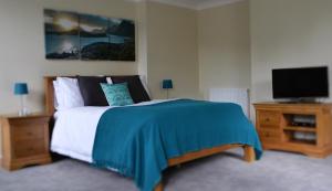 a bedroom with a bed and a flat screen tv at The School House B & B in Bucknell