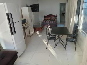 a small kitchen with a table and a refrigerator at Casa proximo ao aeroporto in Florianópolis