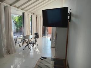 a television hanging on a wall in a living room at Casa proximo ao aeroporto in Florianópolis