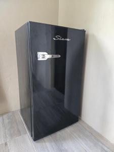 Un refrigerador negro con un asa en la pared. en La Tata, en Veronica