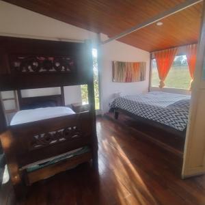 Un dormitorio con dos literas y una ventana. en Finca La Aurora Hospedaje Rural de Montaña, en Tibasosa