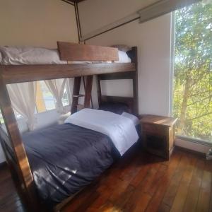 Un dormitorio con dos literas y una ventana. en Finca La Aurora Hospedaje Rural de Montaña, en Tibasosa