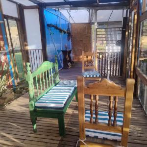 un porche con 2 sillas y un columpio en Finca La Aurora Hospedaje Rural de Montaña, en Tibasosa