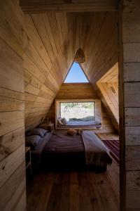 a large bed in a wooden room with a window at Very Muy Epico in San Lucas del Pulque