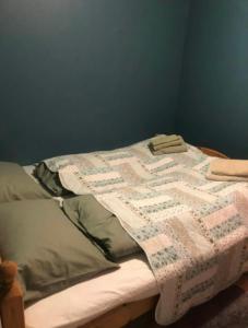 Una cama con una colcha encima en una habitación. en Leilighet i Damstien, 