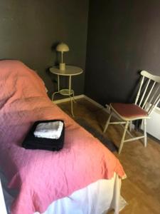Un dormitorio con una cama, una silla y una mesa. en Leilighet i Damstien, 