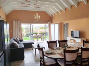 The Fifth Tee Villa في Stompneusbaai: غرفة طعام مع طاولة وأريكة
