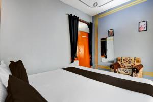 a bedroom with a bed and a chair at HOTEL O STAY INN Lucknow Airport VIP Terminal in Transport Nagar