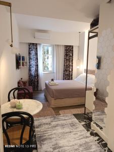 una stanza d'albergo con un letto e un tavolo di MUSES LUXURY SUITES a Città di Corfù