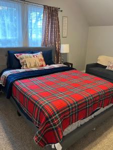 a bedroom with a bed with a plaid blanket at My house your house in Fort Smith