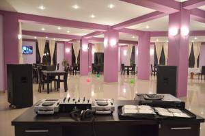 a large room with purple walls and tables and chairs at Rasarit de Soare in Rotbav