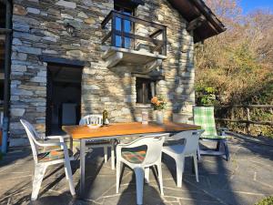 a wooden table and chairs on a patio at Rustico Kevin by HolAp SA in Brissago