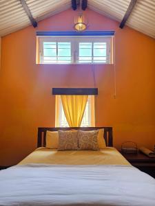 ein Schlafzimmer mit einem Bett und einem Fenster in der Unterkunft The Cottage Coonoor AS in Coonoor