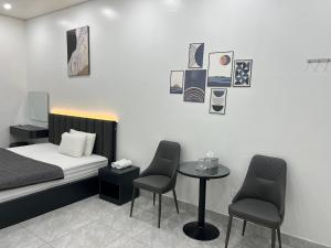 a room with a bed and two chairs and a table at MoHa Hotel in Hanoi