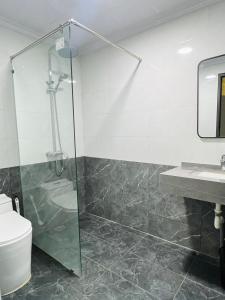a bathroom with a shower and a toilet and a sink at MoHa Hotel in Hanoi