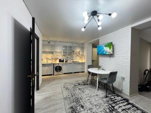 ein Wohnzimmer mit Tisch und Küche in der Unterkunft 1-Confortable and ideal Apartament-Квартира посуточно Edinet in Edineţ