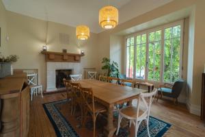 een eetkamer met een tafel en stoelen en een open haard bij Villa Le Dupleix in Arcachon