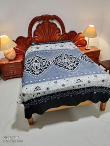 a bed with a blue and white quilt on it at Amplía casa en Jardines Alcalde in Guadalajara