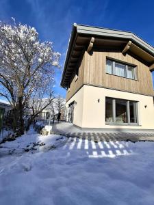 Cute House with terrace and garden في إنسبروك: أمامه بيت فيه ثلج