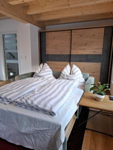 Cute House with terrace and garden في إنسبروك: سرير كبير في غرفة مع اللوح الخشبي