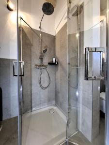 Cute House with terrace and garden في إنسبروك: دش مع باب زجاجي في الحمام +12 صورة