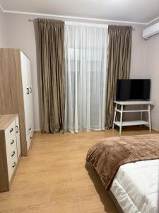 Un dormitorio con una cama y un televisor de pantalla plana. en Villa Rusi, 