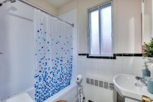 een witte badkamer met een blauw betegeld douchegordijn bij NDG & Montreal getaway in Montreal +20 foto's