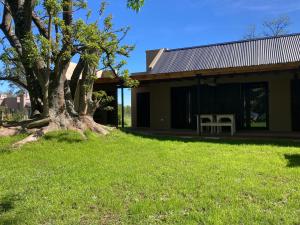 ein Haus mit einem Baum davor in der Unterkunft La Caballeriza in La Porteña