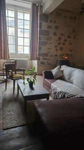ein Wohnzimmer mit Sofa und Tisch in der Unterkunft Gite Maison Loyac in Tulle