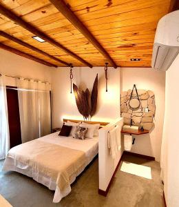 een slaapkamer met een bed met een houten plafond bij CACTUS CLUB - Hotel, Wellness Center & Spa in São Miguel do Gostoso