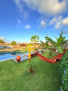 een hangmat in een tuin naast een zwembad bij CACTUS CLUB - Hotel, Wellness Center & Spa in São Miguel do Gostoso