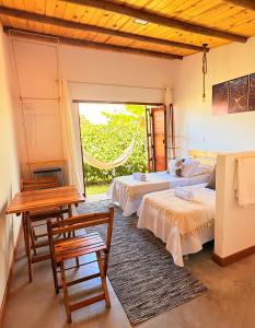 een slaapkamer met twee bedden en een tafel en stoelen bij CACTUS CLUB - Hotel, Wellness Center & Spa in São Miguel do Gostoso +53 foto's