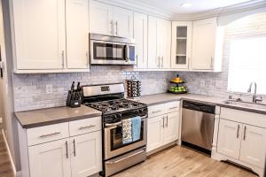 eine Küche mit weißen Schränken und Geräten aus Edelstahl in der Unterkunft Adorable 3 Bedroom 2 Bath Home in Fullerton + 6 Fotos