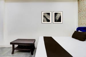 Una mesa y una silla en una pared blanca con dos cuadros. en Hotel O Star Palace, en Akolia 21 fotos más