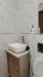a bathroom with a white sink and a toilet at Infinium Stay in Rishīkesh +19 photos