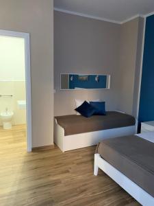 a bedroom with two beds and a bathroom at Titti's Room in Casteldaccia