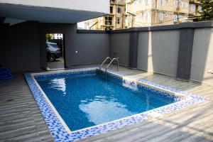 una piscina con azulejos azules en un edificio en B'gatti Apartments, en Lagos