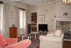 a living room with a couch and a tv at Manoir de la Pataudière B&B in Villers-Canivet