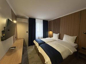 a hotel room with a large bed and a television at Hotel Leotar in Trebinje