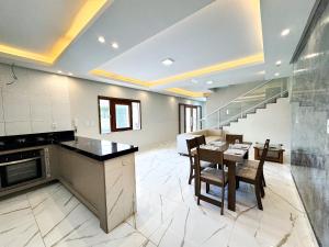 a living room with a table and chairs and a staircase at Eficiência - Casa Recanto dos Ventos in Camocim